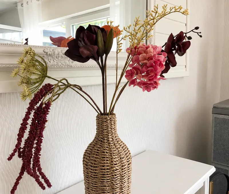 Dekoration im Haus am See Dekorative Vase mit Blumen im Haus am See vor hellem Innenraum.