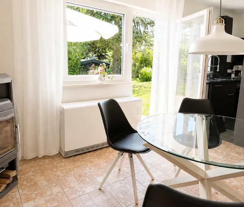 Essbereich am Fenster im Haus am See Essbereich im Haus am See mit Blick zum Fenster und in die offene Kueche.