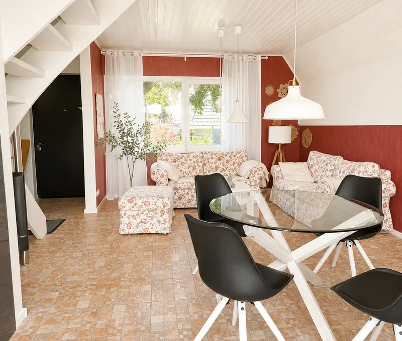Wohn- und Essbereich im Haus am See Wohn- und Essbereich im Haus am See mit Sofa, Esstisch und Treppe zur Galerie.