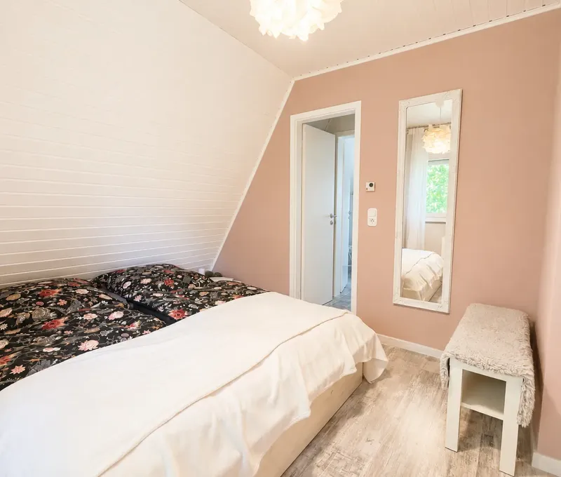 Schlafzimmer im Haus am See Schlafzimmer im Haus am See mit Doppelbett, Dachschraege und hellen Einbauschraenken.