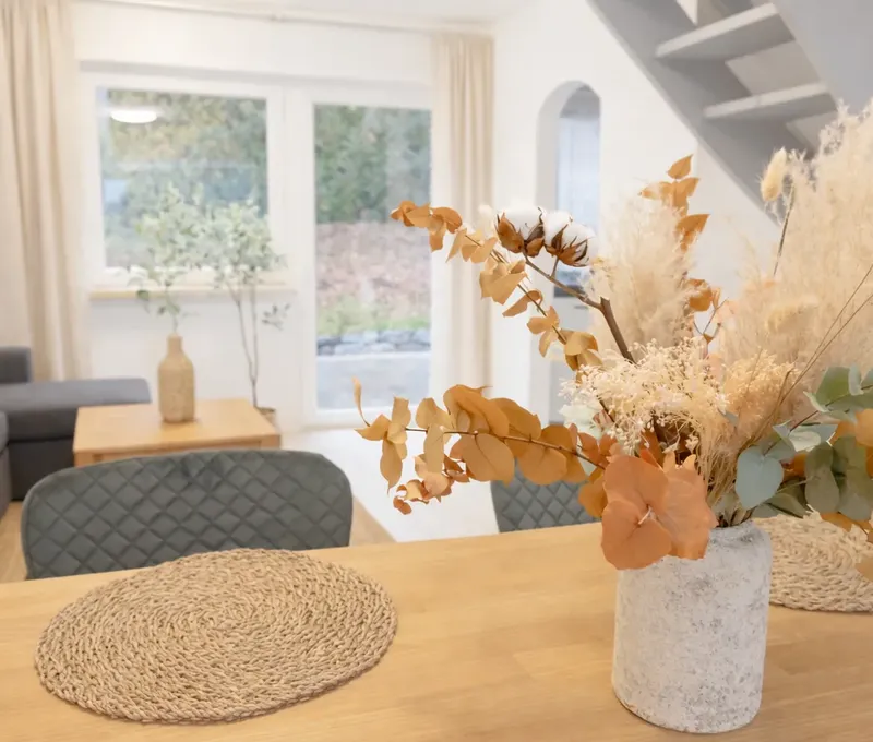 Wohnzimmer und Esstisch im Ferienhaus Seeblick Wohn- und Essbereich im Ferienhaus Seeblick mit Sofa, Esstisch und Dekoration.