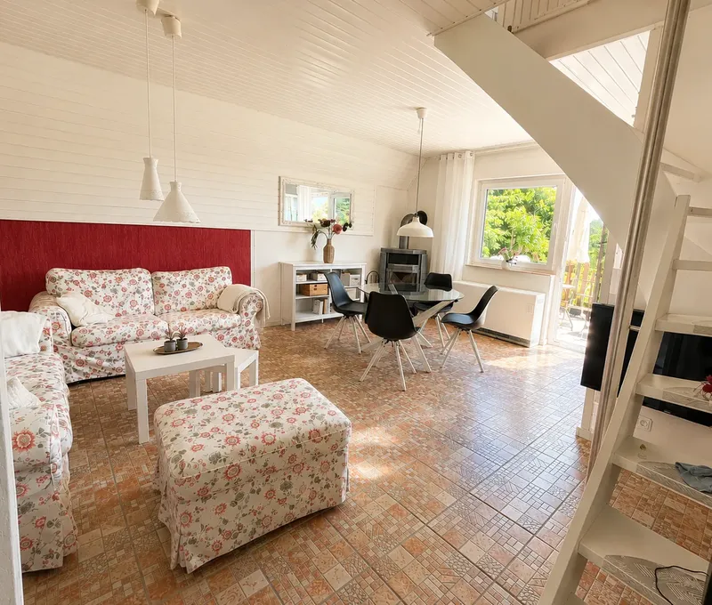 Wohnzimmer mit Treppe im Haus am See Wohnzimmer im Haus am See mit Sofa, Treppe und Galeriegeschoss.