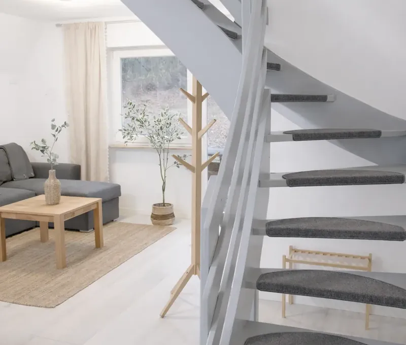 Treppe und Wohnbereich im Ferienhaus Seeblick Blick auf Treppe und Wohnbereich im Ferienhaus Seeblick mit heller Einrichtung.