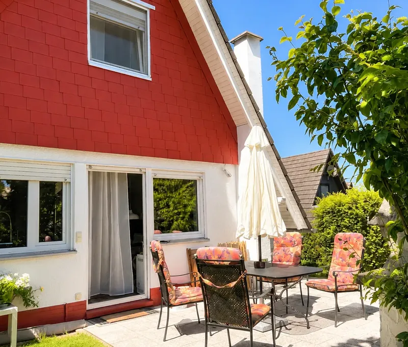 Terrasse und Aussenansicht vom Haus am See Aussenansicht vom Haus am See mit roter Fassade, Terrasse und Garten.