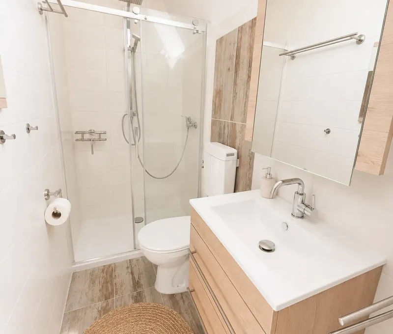 Badezimmer im Haus am See Badezimmer im Haus am See mit Dusche, Waschbecken und hellem Spiegelbereich.