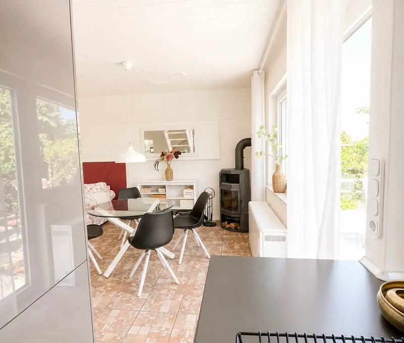 Wohnbereich mit Blick zur Kueche im Haus am See Heller Wohnbereich im Haus am See mit Sofa, Esstisch und offener Kueche.