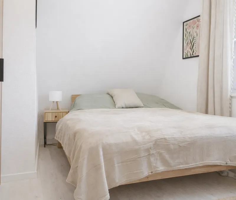 Doppelbett im Ferienhaus Seeblick Schlafzimmer im Ferienhaus Seeblick mit Doppelbett, Nachttisch und hellen Vorhängen.