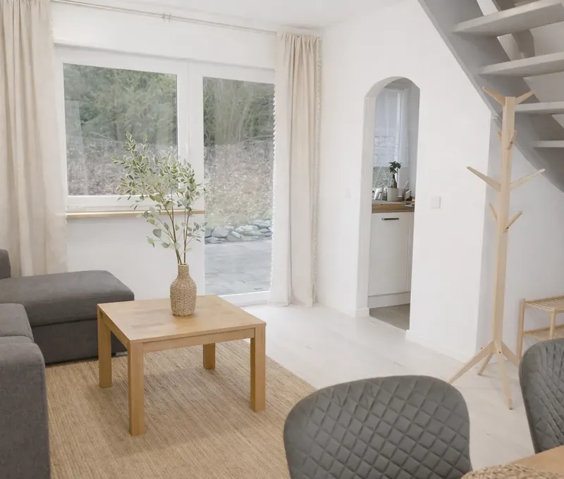 Wohnzimmer im Ferienhaus Seeblick Heller Wohnbereich im Ferienhaus Seeblick mit Sofa, Couchtisch und Treppe ins Obergeschoss.